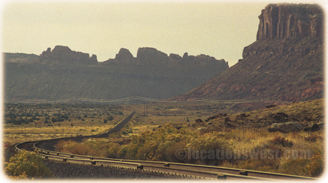 a railroad cuts through redrock canyons